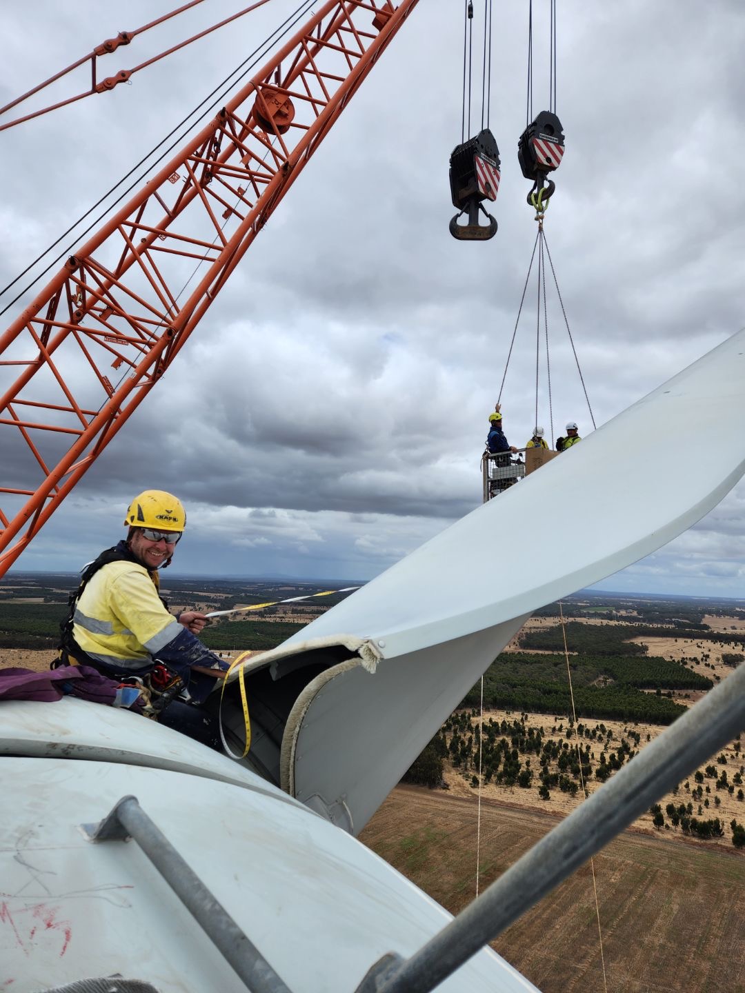 Crane crew performing wind turbine blade maintenance
